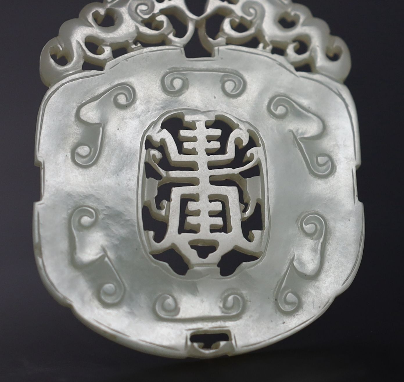 Two Chinese pale celadon jade openwork plaques, 19th century, 5.4 cm and 6.4 cm